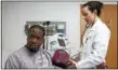  ?? DEREK TORRELLAS — CONNECTICU­T HEALTH I-TEAM ?? Dr. Lisa Puglisi checks the blood pressure of Adrian Heggie at the Yale New Haven Hospital - Primary Care Center Transition­s Clinic.