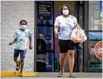  ?? JIM NOELKER/STAFF ?? Lashandra Carey and her son Princeton Flagg carry groceries out of the Kroger on Wayne Ave. Thursday afternoon. The Census Bureau is looking at how Americans spent their stimulus checks.