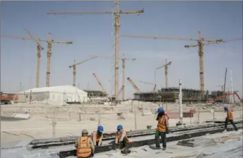  ?? Olya Morvan/The New York Times ?? Workers install tram rails that lead to a stadium in the tiny, oil-rich Gulf state of Qatar.