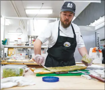  ?? ?? Chef Josh Gjersand prepares a sandwich for students to try.