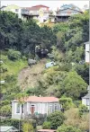  ?? PHOTOS: STEPHEN JAQUIERY ?? Collapse . . . A large slip cut a path of destructio­n down the hillside above Ravenswood Rd, St Clair, on Saturday morning, damaging three cars and a garage.
