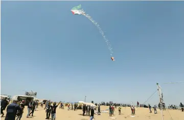  ?? (Ibraheem Abu Mustafa/Reuters) ?? PALESTINIA­NS IN the southern Gaza Strip on Friday fly a flaming kite to be send toward Israeli fields.