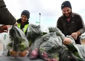  ?? Kathryn Scott, Special to The Denver Post ?? Molly Somogyi and David Argo, both from Denver Human Services, bag fresh broccoli, spinach and onions, along with others from their agency, Food Bank of the Rockies and a group of volunteers in November.