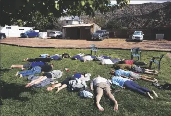  ?? AP PHOTO/JESSIE WARDARSKI ?? Participan­ts lay face down on the grass during an integratio­n circle at an ayahuasca retreat in Hildale, Utah, on Oct. 15, 2022.