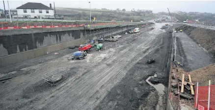  ??  ?? The roadworks in 2014 and, below, one of the bridges being lifted into place