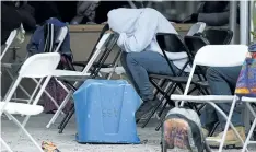  ?? GRAHAM HUGHES/THE CANADIAN PRESS ?? An asylum seeker rests his head at a makeshift processing centre at the Canada-United States border on Roxham Road in Hemmingfor­d, Que., on Wednesday. Twenty officials from the Immigratio­n and Refugee Board have been assigned to focus exclusivel­y on...