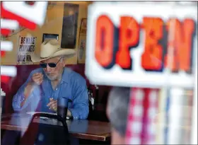  ?? MATT YORK — THE ASSOCIATED PRESS ?? A customer eats inside the Horseshoe Cafe on Friday in Wickenburg, Ariz. A few small businesses reopened in defiance of Arizona Gov. Doug Ducey’s decision to extend a statewide stay-at-home order for another two weeks.