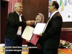  ??  ?? RADZALI (kiri) bertukar dokumen perjanjian dengan Roslee.