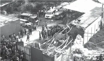  ?? ASSOCIATED PRESS ?? Police officers and rescuers inspect the site of an explosion at a firecracke­r factory in Tangerang, on the outskirts of Jakarta, Indonesia.