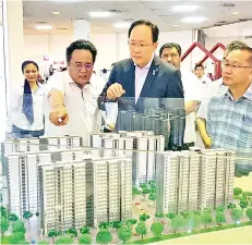  ??  ?? Teo (centre) being briefed on a PR1MA housing project offered at the expo at Sabah Trade Centre yesterday.