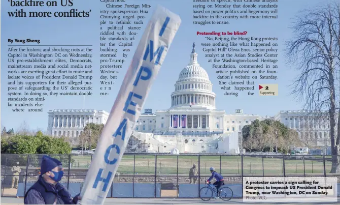  ?? Photo: VCG ?? A protester carries a sign calling for Congress to impeach US President Donald Trump, near Washington, DC on Sunday.