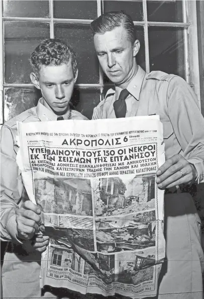  ?? THE COMMERCIAL APPEAL FILES ?? Pictures in a Greek newspaper recall to Maj. Eugene Cook, right, of 4735 Lynn Road the earthquake-battered Ionian Islands of Greece in August 1953. He shows civil Air Patrol Cadet Frank Isele of 1921 Netherwood the scenes he saw while flying low over the isles just as the quake was shaking them. Maj. Cook and young Isele returned recently after a month-long CAP-sponsored tour of Europe.