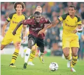  ?? FOTO: DPA ?? Hannovers Ihlas Bebou (rotes Trikot) gegen die Dortmunder Manuel Akanji (re.) und Axel Witsel.