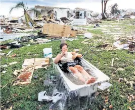  ?? ?? In ‘Untitled,’ shot in 1992, Marjorie Conklin cools off in a tub of water filled with a hose, surrounded by what’s left of her south Miami-Dade County home several days after the destructio­n of Hurricane Andrew.