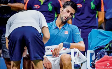  ?? AFP ?? Novak Djokovic of Serbia gets his arm attended by his trainer during the men’s singles match against Poland’s Jerzy Janowicz. —