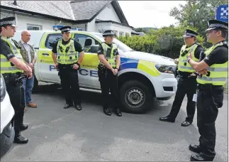  ?? 01_B35police0­3 ?? Chief Superinten­dent Faroque Hussain, the local police commander, right, is seen chatting to the summer police officers and special constable Andrew Perrie during his first visit to Arran this week.