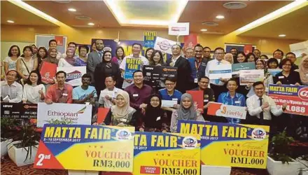  ?? [FOTO HALIM SALLEH/BH] ?? KL Tan (tengah) bersama pemenang cabutan bertuah MATTA Fair pada majlis penyampaia­n hadiah di Pusat Dagangan Dunia Putra, semalam.