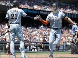  ?? AP/BEN MARGOT ?? Miami outfielder Giancarlo Stanton (right) is met by Christian Yelich after hitting the first of his two home runs in a 10-8 victory over San Francisco in 11 innings on Sunday. Stanton is expected to show plenty of power in tonight’s MLB Home Run Derby...