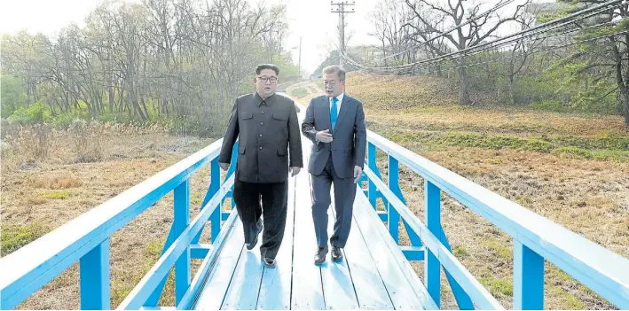  ?? AP ?? Histórico. El lider norcoreano Kim Jong-un habla a solas sobre un puente con el presidente socialdemó­crasta surcoreano Moon Jae-in durante el histórico encuentro del viernes.
