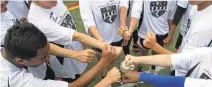  ?? PATRICK TEHAN/STAFF PHOTOS ?? Above: Afghan refugee Naeim Akrami, 19, of Hayward, plays the ball as teens from Archbishop Mitty High School hos a soccer match Saturday in San Jose. Right: The White team prepares to cheer before the game. The refugees have been resettled in the Bay...