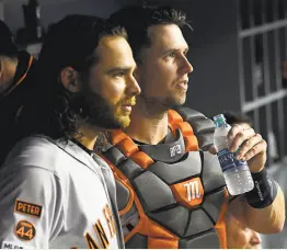  ?? Jayne Kamin-Oncea / Getty Images 2019 ?? Brandon Crawford and Buster Posey watch the action from the Giants’ dugout during a 2019 game at Dodger Stadium.