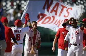  ?? NICK WASS - THE ASSOCIATED PRESS ?? Washington Nationals’ Carter Kieboom (8) high-fives Alex Avila (6) after hitting a walkoff single to drive in Josh Bell during the ninth inning of a baseball game against the New York Mets, Monday, Sept. 6, 2021, in Washington. Nationals’ Alcides Escobar, right, looks on.