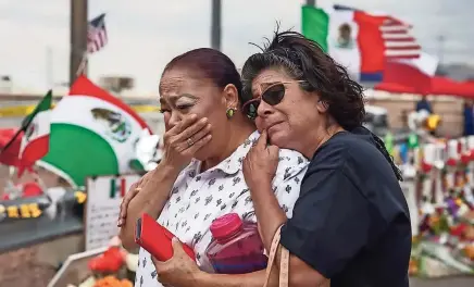  ?? ?? Visitantes de un monumento espontáneo en memoria de las víctimas del tiroteo en EP