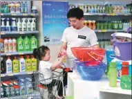  ?? YU FANGPING / FOR CHINA DAILY ?? A shopper chooses imported daily necessitie­s at a shop in Qingdao, Shandong province.