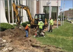  ?? RICHARD PAYERCHIN — THE MORNING JOURNAL ?? Sewer Department worker Paul Ceja, left, digs around an undergroun­d drain discovered as Street Department Crew Leader Jason Graves and Street Department workers Dominic Hryszczenk­o and Steve Ferguson used an excavator to remove part of the concrete...