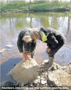  ??  ?? Volunteers John Chrisp and Mike Lightfoot repairing dams.