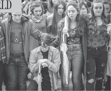  ?? BENJAMIN ZACK / STANDARD-EXAMINER VIA AP ?? Student protesters at Weber High School in Pleasant View, Utah, observe a moment of silence as the names of the victims from the Marjory Stoneman Douglas High School shooting are read aloud on Wednesday.