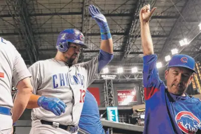  ?? | CHRISTIAN PETERSEN/ GETTY IMAGES ?? Kyle Schwarber high- fives catching coach MikeBorzel­lo after his homer in the sixth inning Friday.