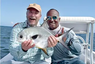  ?? Photo by Chris Santella for The Washington Post ?? ■ Nelson Mathews and guide Scully Garbutt show off Mathews’s second permit of the trip.