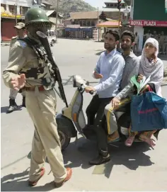 ?? AFP ?? A paramilita­ry trooper stops a Kashmiri family as they try to take a patient to hospital on the 12th day of the curfew in downtown Srinagar. —