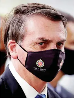  ?? Foto: dpa/Eraldo Peres ?? Militanter Mundschutz mit klarer Ansage: Das Logo auf Jair Bolsonaros Maske lautet »Militärpol­izei, Föderaler Bezirk«.