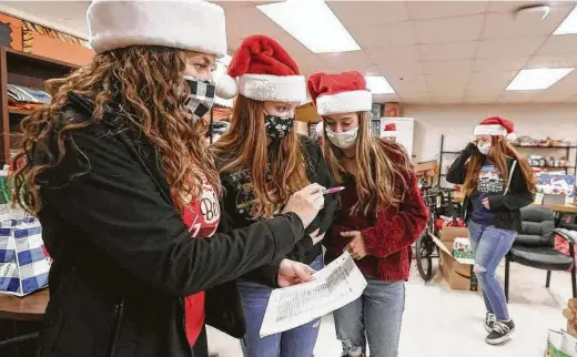  ?? Jason Fochtman / Staff photograph­er ?? MistyWesto­ver, left, goes over plans with her daughter, Olivia, and Madie Moore as they volunteer at Conroe High School on Thursday.