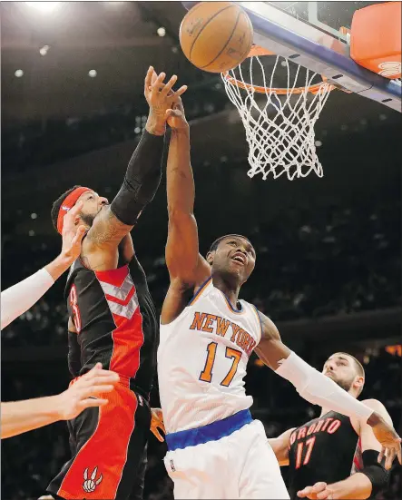  ?? — THE ASSOCIATED PRESS ?? Toronto Raptors’ James Johnson, left, and the Knicks’ Cleanthony Early fight for control of the ball during the first half of an NBA game Saturday night in New York.