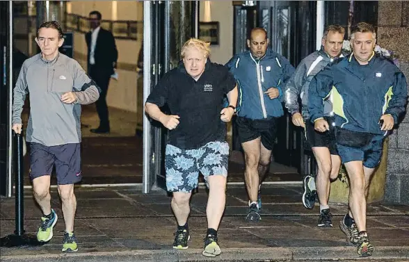  ?? CARL COURT / GETTY ?? Boris Johnson (en el centro) salió a correr ayer en Manchester con el director del diario The Sun, Tony Gallagher (a la izquierda)