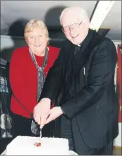  ?? ?? Peggy Condon and Canon Patrick Twomey cutting the cake at the Kildorrery senior citizens Christmas party in December 2000.