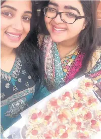  ??  ?? ●●Tasnim Khalid (left) and her sister Fathma Khalid taking desserts to a family celebratio­n during Eid