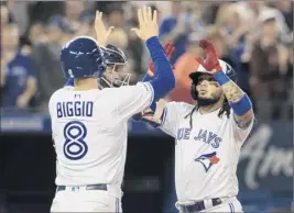  ?? Fred Thornhill / The Canadian Press via AP ?? The Blue Jays’ Freddy Galvis is met at home plate by Cavan Biggio (8) after Galvis drove him in with a two-run homer during the fifth inning.