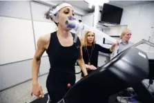  ?? AP PHOTO/STEVEN SENNE ?? Research scientist Leila Walker, left, is assisted by nutritiona­l physiologi­st Holly McClung, center, as they demonstrat­e equipment on April 23 in Natick, Mass. The machines were designed to evaluate fitness levels in female soldiers, not shown, who have joined elite fighting units.