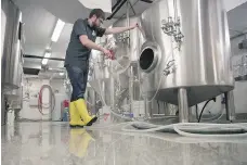  ??  ?? Nathan Kary, brewmaster at Pile O’ Bones brewery in Regina, cleans some equipment. Their unpasteuri­zed beer will be sold and delivered independen­tly to private stores once the canning line is operationa­l.