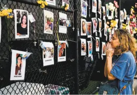  ?? Chandan Khanna / AFP via Getty Images ?? A woman prays in front of photos at a makeshift memorial for the victims of the building collapse, near the site of the accident in Surfside, la.