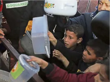  ?? ?? DESPERATE: People gather for water in the southern Gaza city of Rafah yesterday.