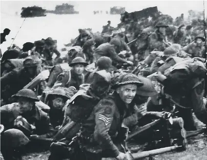  ??  ?? Sergeant Albert Speller, facing the camera, on a D-Day beach.