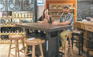  ?? ANGELA DOUGLAS/FOR THE DAILY PRESS ?? Aletha Norris and Russ Tinsley sit at the Oozlefinch furniture line in the Haynes store in Virginia Beach on Nov. 12. Most of the products come with the option for a “blonde” or “stout” distressed finish.