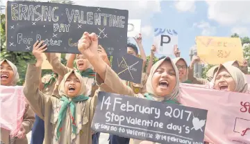  ??  ?? Muslim students shout slogans during a protest against Valentine’s Day celebratio­ns in Surabaya, Indonesia, on Monday. — Antara Foto/ Reuters photo
