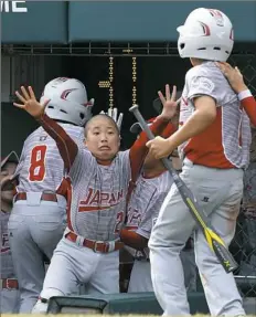  ?? Gene J. Puskar/Associated Press ?? Japan's Takuma Kashiwagur­a celebrates as teammate Rei Ichisawa returns to the dugout after scoring on a double.