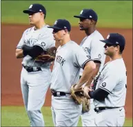  ?? Chris O'Meara / Associated Press ?? Yankees infielders look on as pitcher Michael King warms up against the Rays during the fifth inning on Thursday.